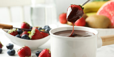 strawberry dipped into a cup of chocolate fondue