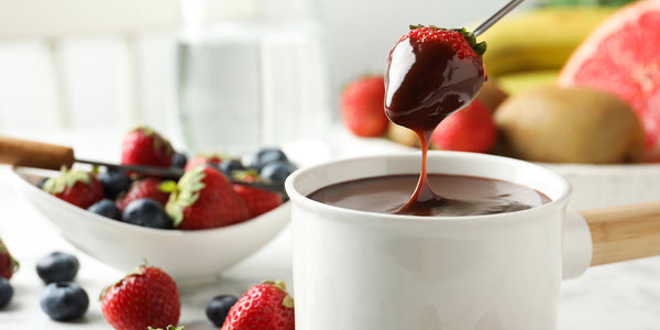 strawberry dipped into a cup of chocolate fondue 